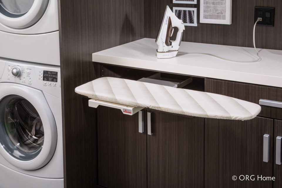 retractable ironing board in an organized laundry room