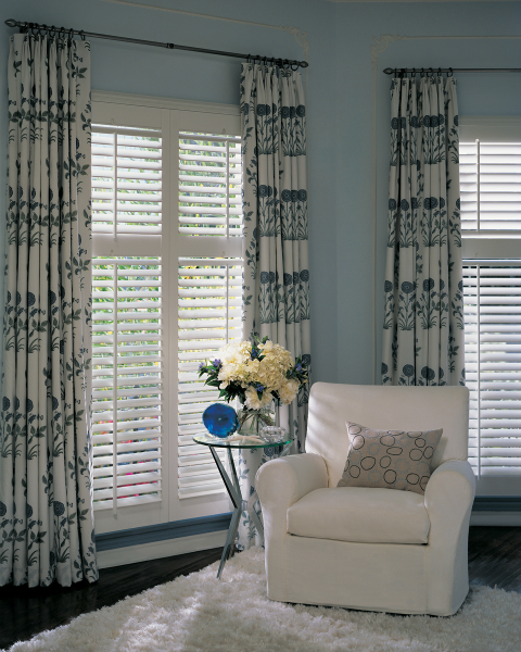 NewStyle® hybrid shutters with Front Tilt Bar by Hunter Douglas can be paired with a simple rod and fabric panels for a soft, elegant look.