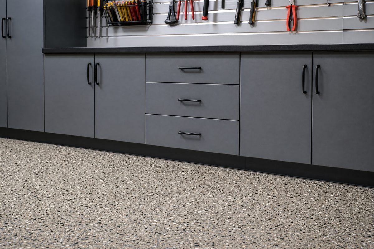 Epoxy garage floor with color flakes meeting gray custom cabinets in a downtown Wilmington garage